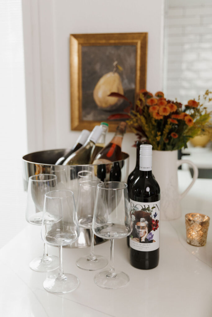 Assortment of wine bottles and glasses on fall table with candlelight
